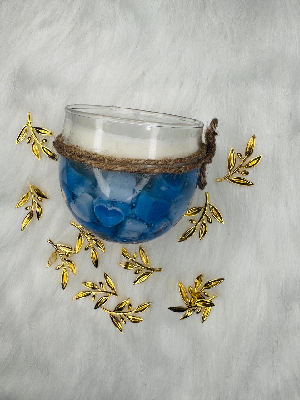 blue gel candle with heart shapes inside glass cup white wax top and rustic twine decoration with gold leaf accents